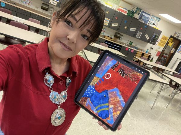 Weeya Calif holding an iPad with her art in her art classroom.